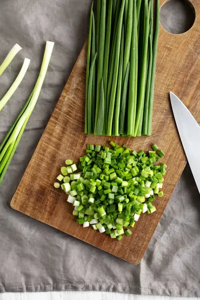 Tahta üzerinde organik kesilmiş yeşil soğan soğanı, üst manzara. Genel giderler.
