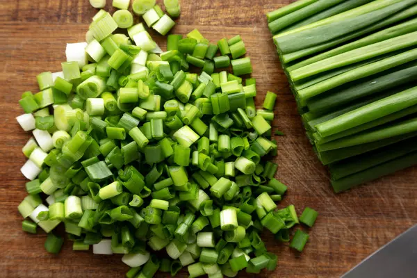 Tahta üzerinde organik kesilmiş yeşil soğan soğanı, üst manzara.. 