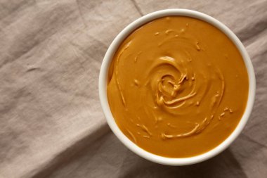 Kâsede organik fıstık ezmesi, üst manzara. Düz uzanın, başınızın üstünde. 