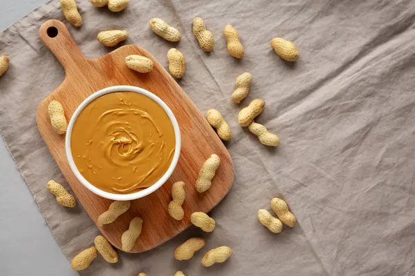 Kâsede organik fıstık ezmesi, üst manzara. Düz uzanın, başınızın üstünde.