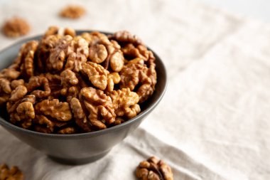 Tabaktaki çiğ ceviz yarımları, yan manzara. Boşluğu kopyala.