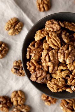 Bir kasede çiğ ceviz yarımları, üst manzara. Dümdüz, tepede. Yakın plan..