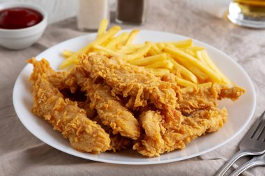 Tabakta patates kızartması olan ev yapımı tavuk şeritleri. Düşük açılı. Yakın plan..