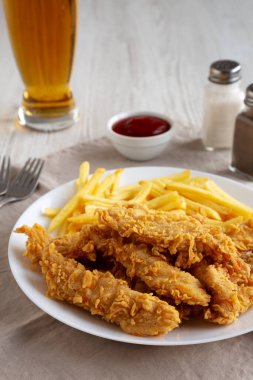 Tabakta patates kızartması olan ev yapımı tavuk şeritleri. Düşük açılı. Yakın plan..