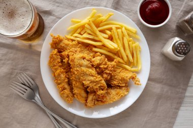 Tabakta patates kızartması olan ev yapımı tavuk şeritleri.. 