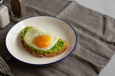 Tabakta yumurta ve ev yapımı Avokado tostu, yan görüş. Boşluğu kopyala.