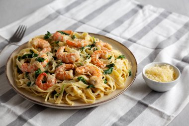 Tabakta ev yapımı kremalı ıspanaklı karides makarna, yan görünüm..