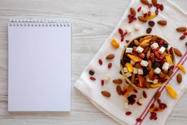 Sağlıklı kurutulmuş meyve ve fındık karışımı, boş not defteri, üst görünüm.. 