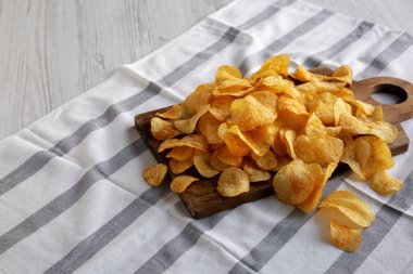 Tahta tahtada ev yapımı peynirli patates cipsi, yan görüş. Boşluğu kopyala.