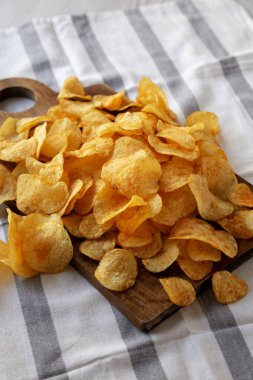 Tahta tahtada ev yapımı peynirli patates cipsi, yan görüş. Boşluğu kopyala.