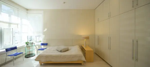高級アパートのベッドルームのライトベージュのトーンにモダンなスキャンダルインテリア 居心地の良いベッド 巨大なワードローブ — ストック写真
