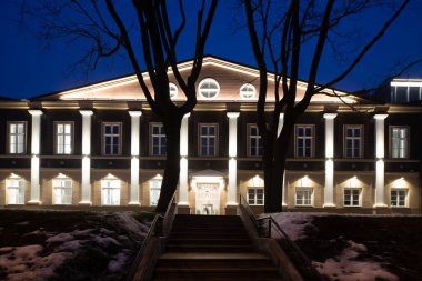 Alacakaranlıktaki aydınlanmış modern binanın dışı. Şehir mimarisi.