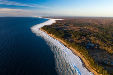 Kışın Baltık Denizi 'nin manzaralı manzarası. Kumda kar. Çam ormanı. Hava görünümü.