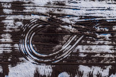 Baharın ilk zamanlarındaki kirli su birikintileri ve eriyen buzlarla dolu bir arazi. Donmuş toprakta kar ve su. Güneşli bir gün.
