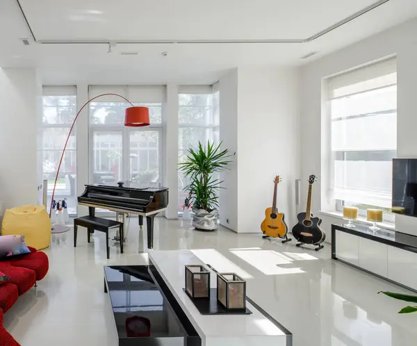 高級なプライベートハウスのモダンなインテリア 赤いソファー ピアノ ギター ホワイトテーブル付きの広々としたリビングルーム — ストック写真