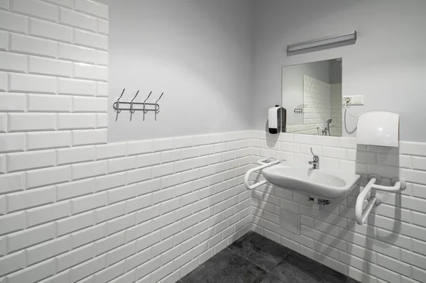stock image The interior of bathroom with facilities for the disabled. White bricks. Grey tile.