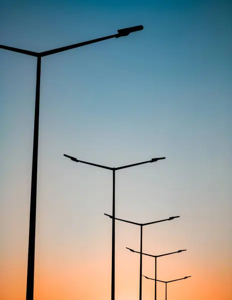 Street lights on the highway against the backdrop of the sunset sky