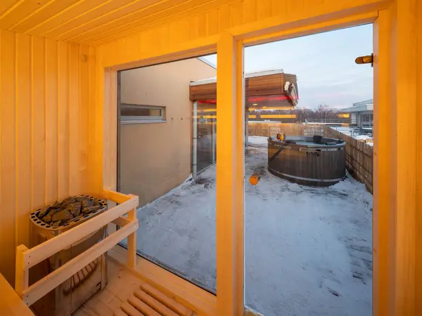 Interior of small wooden finnish sauna with glass door. Luxury private house.