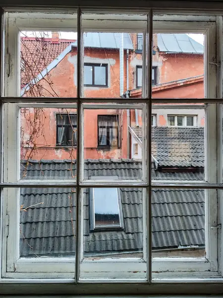 オールドウィンドウ 古い建物の黒い屋根と赤い壁を見ることができます ヨーロッパ — ストック写真