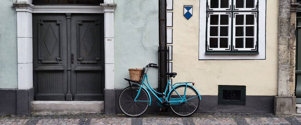 Bicycle parked in front of old house. Facade of building in Old town.