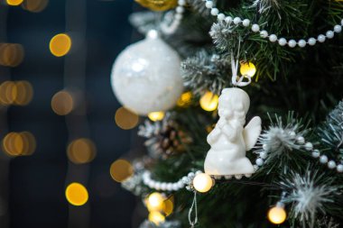 Beyaz top, boncuklar, melek oyuncağı, çelenk ışıkları. Noel ağacı