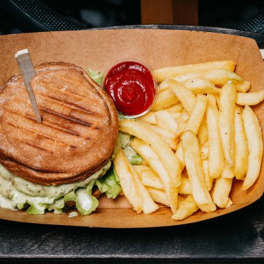 Hamburger, patates kızartması ve karton kutunun içine koyun. Fast food.