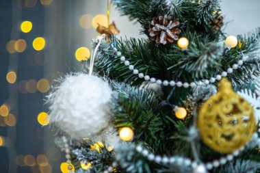 Beyaz top, boncuklar, parlak çelenk ışıkları. Noel ağacı.