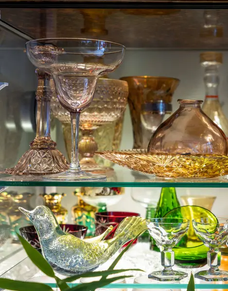 Vintage glassware on shelf in cupboard. Candy bowl in shape of bird.