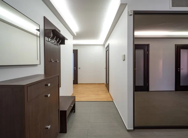 Modern interior of entrance hall in luxury apartment. Mirror sliding door wardrobe.