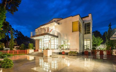 Alacakaranlık 'taki lüks özel evin modern dış cephesi. Aydınlatılmış kulübe.