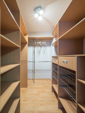 Modern lüks dairedeki boş gardırop dolabının manzarası. Ahşap raflar.