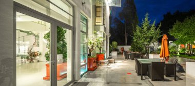 Alacakaranlık 'taki lüks özel evin modern dış cephesi. Aydınlatılmış teras.