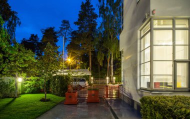 Lüks özel evin modern dış cephesi. Yazın alacakaranlıkta aydınlatılmış kır evi.