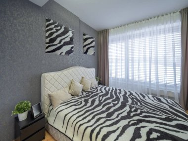 Lüks özel evdeki yatak odasının modern iç mekanı. Sıcak yatak. Zebra yatak örtüsü.