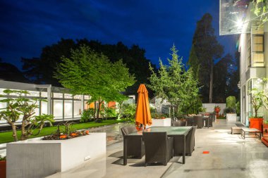 Alacakaranlık 'taki lüks özel evin modern dış cephesi. Aydınlatılmış teras.