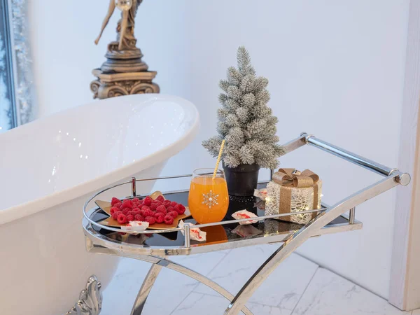 Ahududu, portakal suyu, paketlenmiş hediye. Noel ağacı.