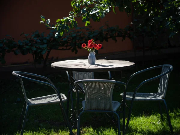 Τραπέζι Και Καρέκλες Στον Καλοκαιρινό Κήπο Κόκκινα Λουλούδια Στο Βάζο — Φωτογραφία Αρχείου