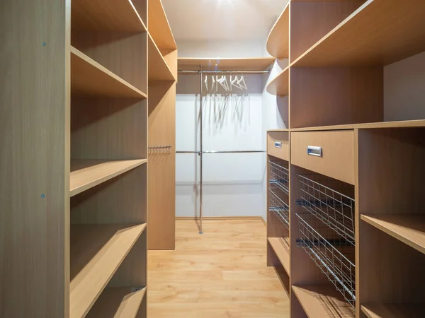 Modern lüks dairedeki boş gardırop dolabının manzarası. Ahşap raflar.