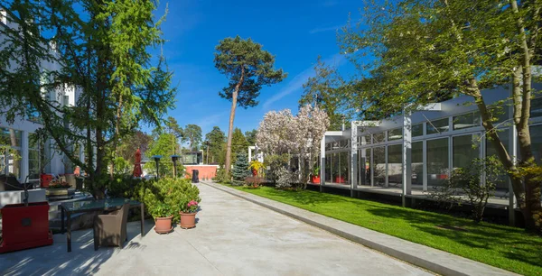 Lüks özel evin modern dış cephesi. Güneşli bir yaz günü. Yeşil çimenler. Güzel bahçe.