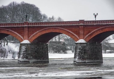 Nehrin üzerindeki tuğla köprü. Kış doğası.