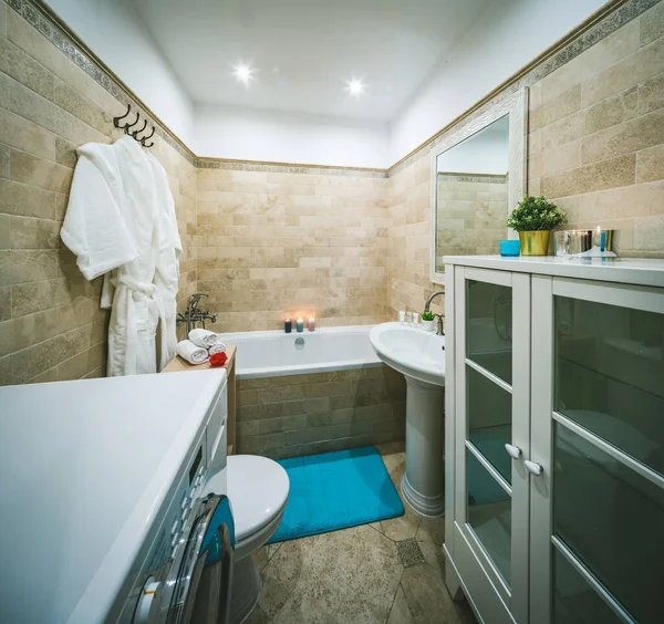 Banyo içi. Çamaşır makinesi. Beyaz lavabo, tuvalet ve banyo..