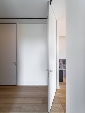 Tavana çıkan beyaz ahşap kapı.