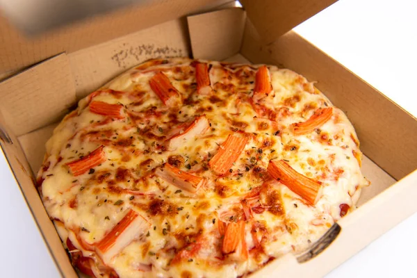 Close up of a Pizza in a cardboard box against on white backgroun