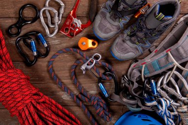 Tırmanma ekipmanları dağcılık ve yürüyüş kask, çekiç, karabina, yürüyüş ayakkabıları ve diğer için ahşap arka plan, üst manzara