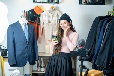 Asyalı blogcu veya Vlogger canlı yayında ürünü sosyal medya üzerinde çevrimiçi etkileyen, İçerik yaratıcısı kavramı üzerinde gözden geçiriyor.