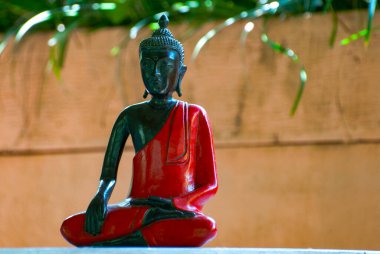 Buddah 'nın ahşap küçük heykeli Endonezya' nın Bali adasındaki Canngu 'da bir villada kırmızıya boyanmış. Kapat.