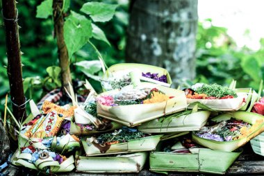 Taman Beji Griya Şelalesi, Kabupaten Badung, Bali, Endonezya 'daki Hindu tapınağında çiçek ve çiçek dolu sepetler.