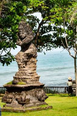 2024 Mart - Endonezya, Bali 'deki Tanah Lot yakınlarındaki Batu Bolong Tapınağı' ndaki taş heykelin kapatılması. Bir muhafız olarak Hindu tapınağının girişinde duran güzel detaylarla oyulmuş bir heykel. Bali kültürü.