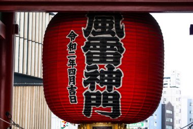 TOKYO, JAPONYAN - Nisan 2024: Senso-ji tapınağındaki Kaminari-mon 'da büyük bir Japon kırmızı feneri. Kırmızı büyük fenerdeki karakterler rüzgar tanrısının ve gök gürültüsünün kapısıdır..