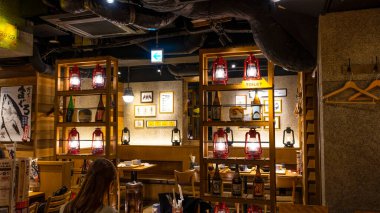 Japonya, Nisan 2024: Tokyo, Japonya 'nın Shinjuku ilçesindeki küçük geleneksel Japon restoranında yemek yiyen genç kız